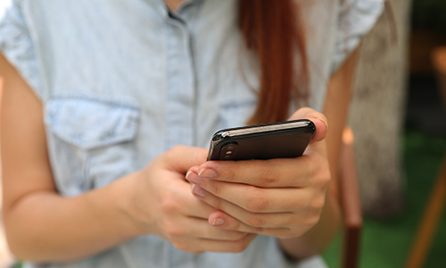 Woman using a cell phone in front of her